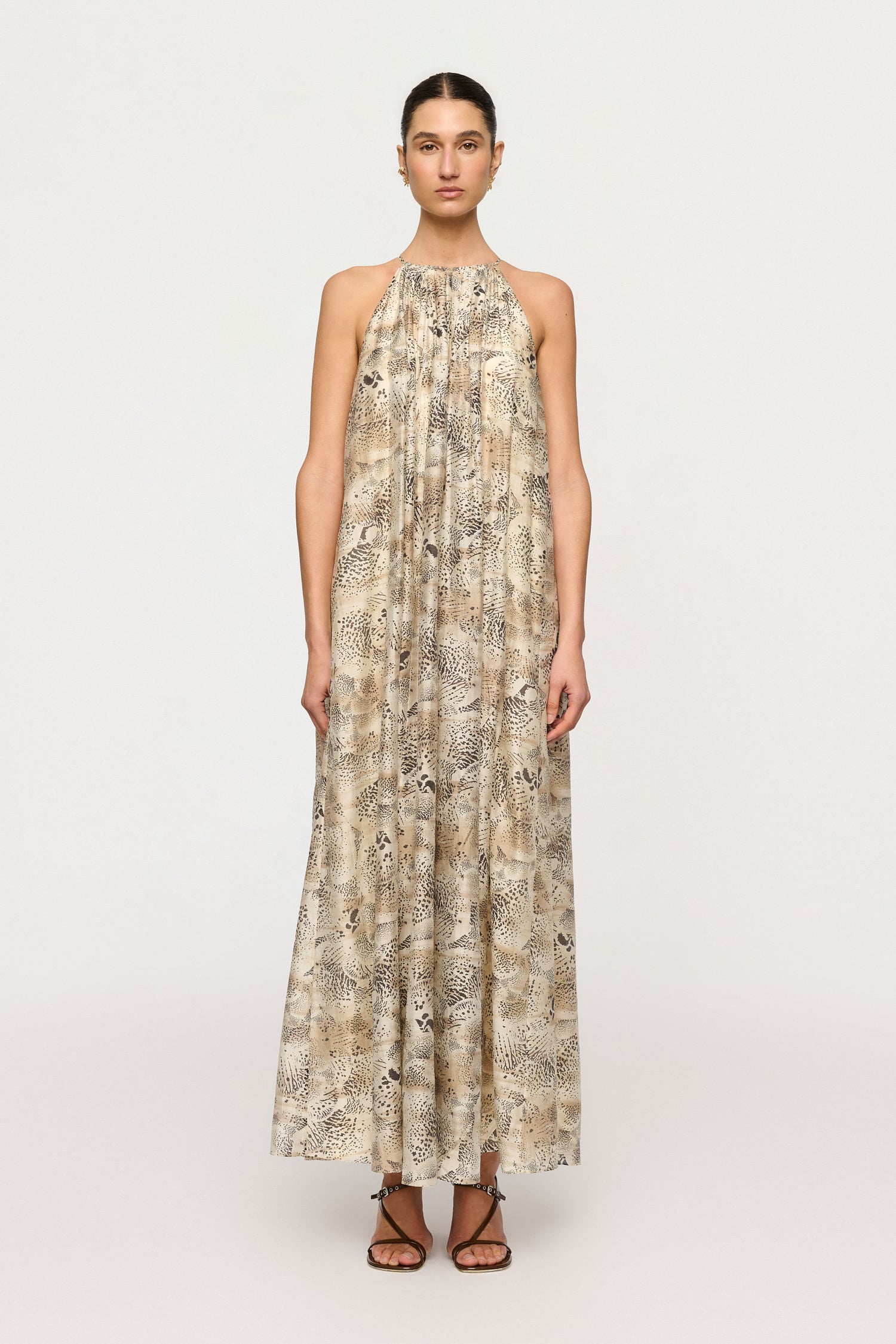 Woman wearing a long, patterned dress on a white background