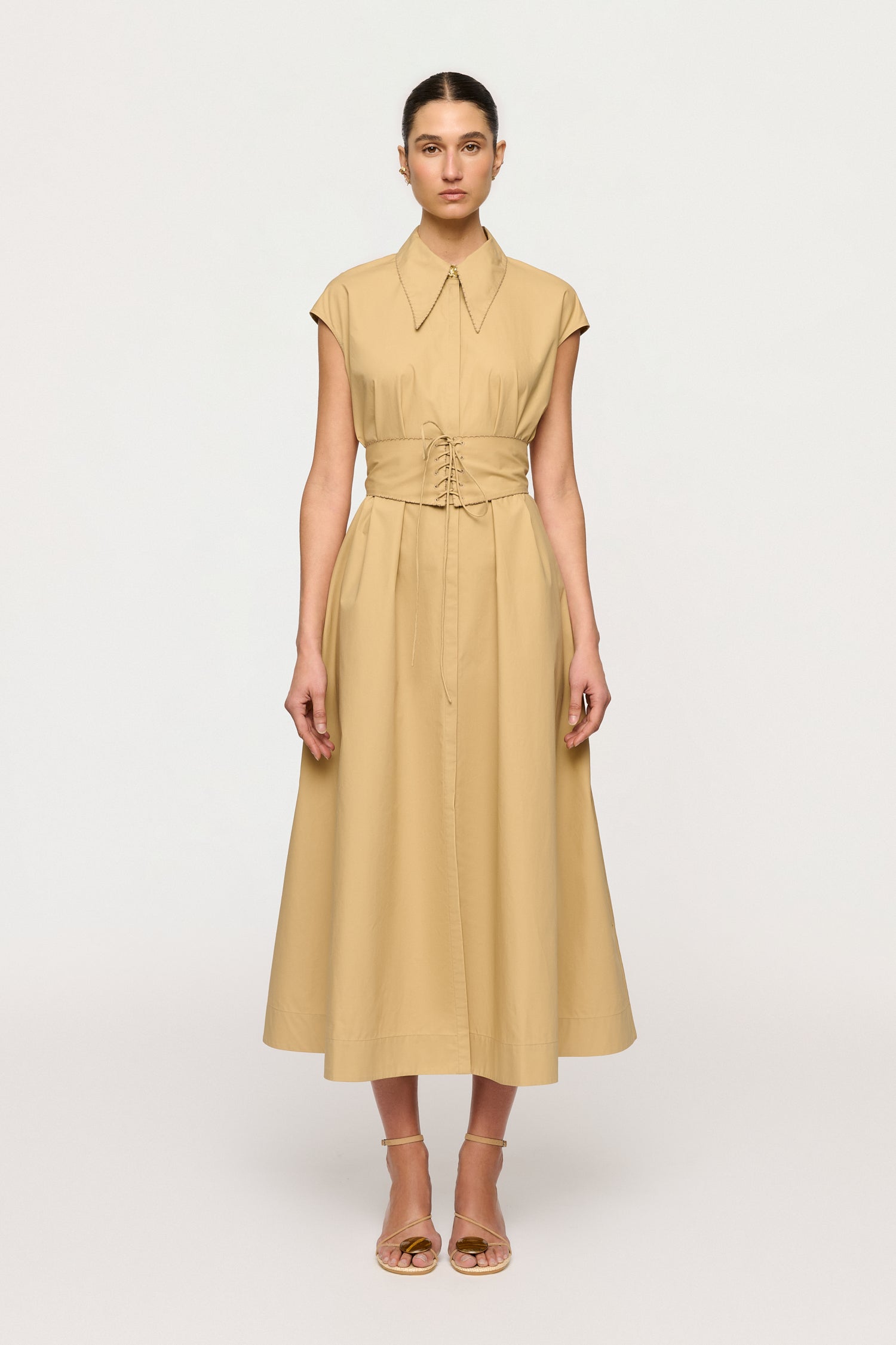 Woman wearing a beige dress on a white background