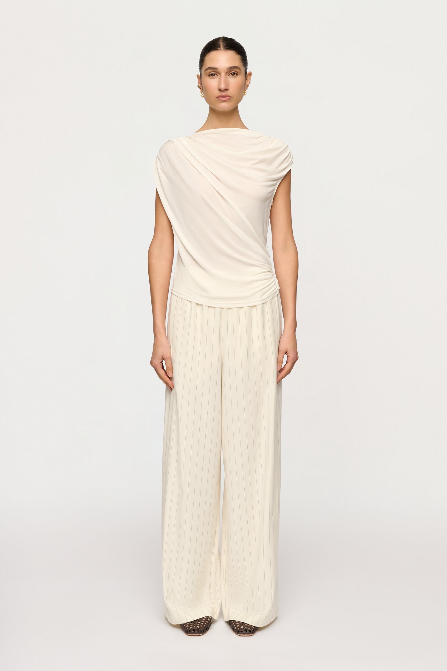 Woman wearing a cream-colored dress on a white background