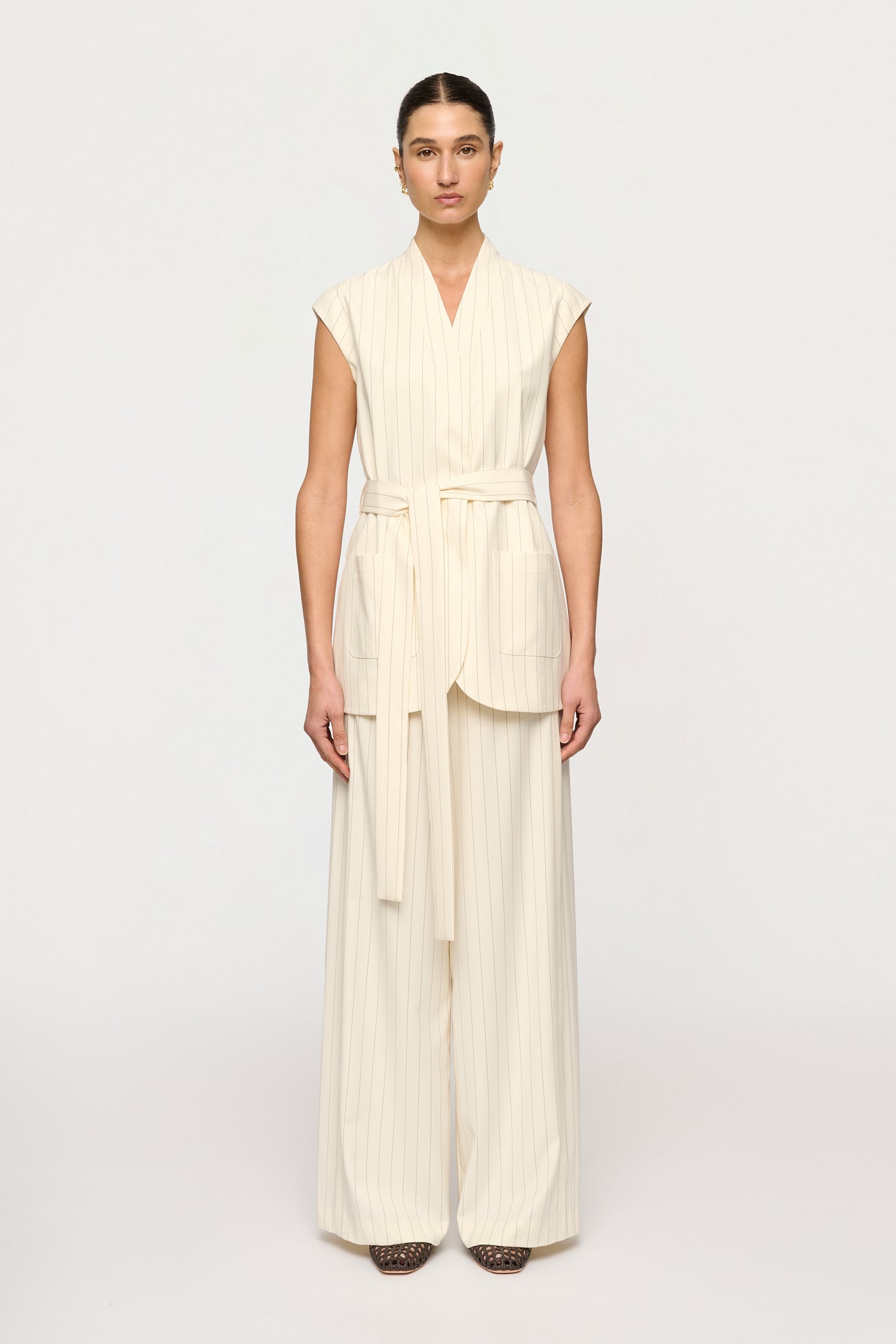 Woman wearing a cream-colored outfit on a white background