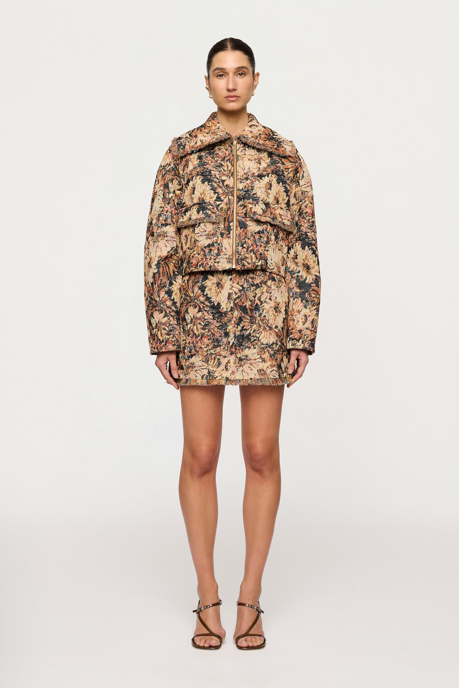 Woman wearing a floral patterned outfit on a white background