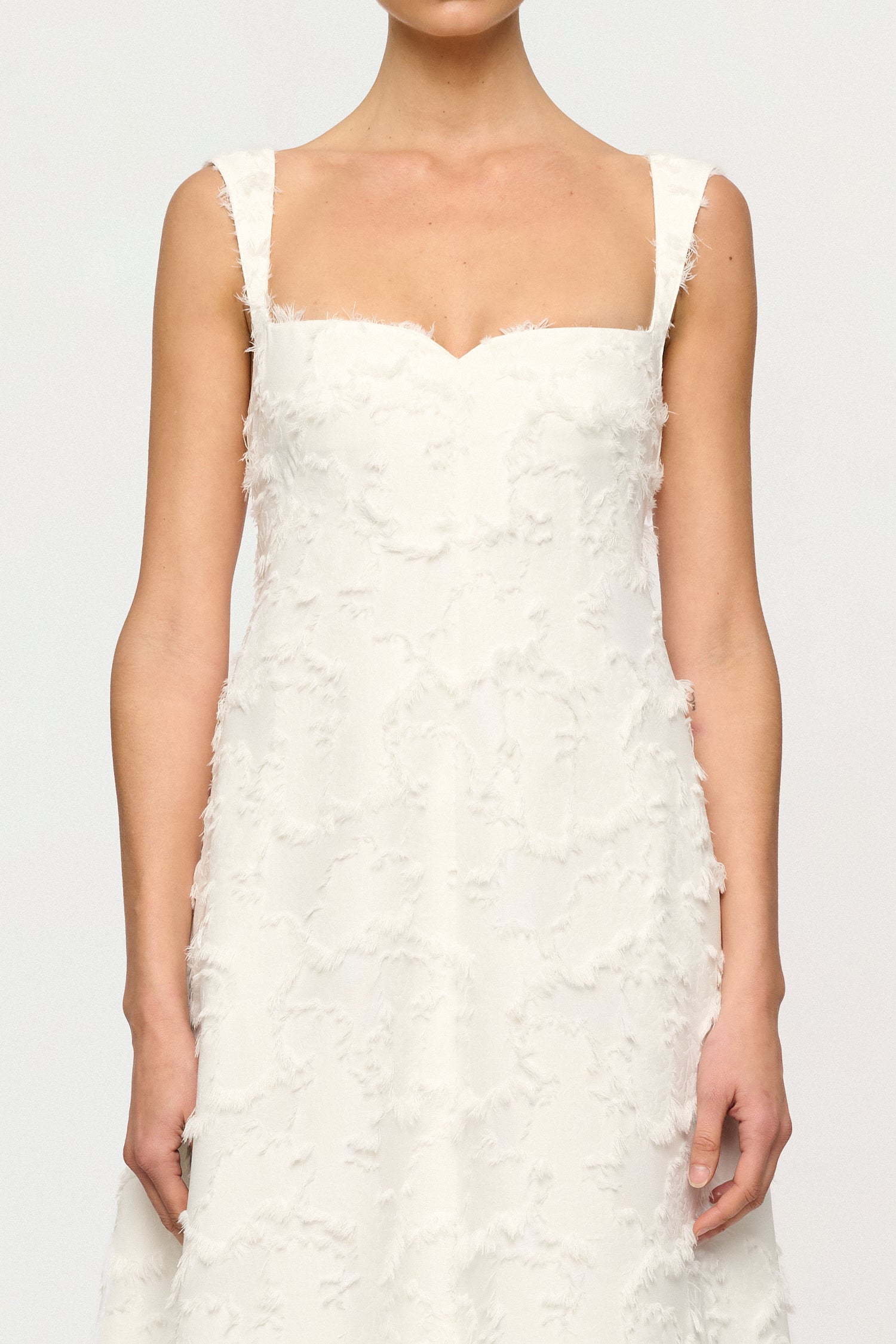White Clea dress with floral textured details on a plain background