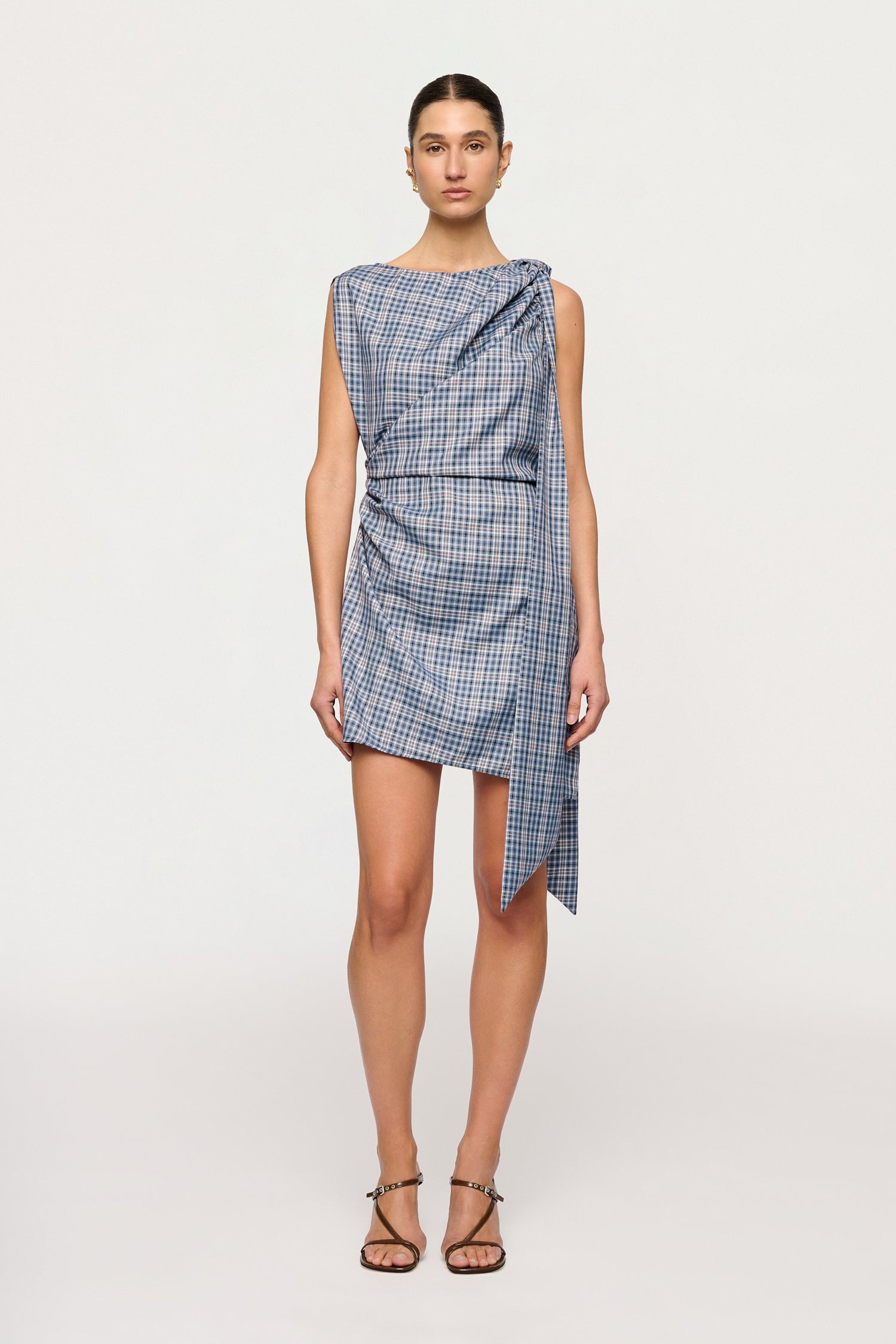 Woman wearing a blue checkered dress on a white background